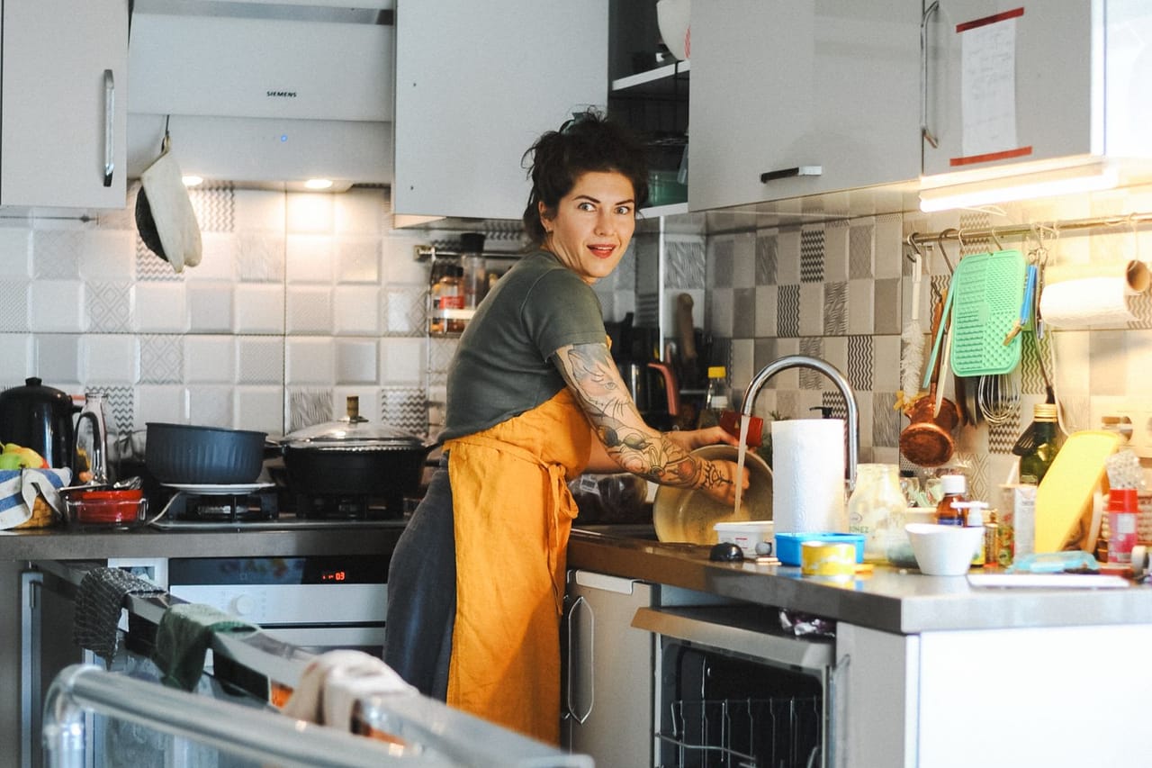 Appliance repair Asheville NC: Woman cooking in modern kitchen with appliance