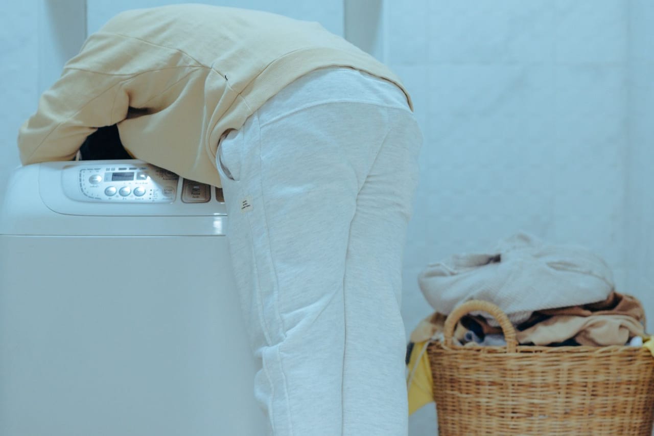 Appliance repair Bay City MI: Funny little kid taking out clothes from washing machine