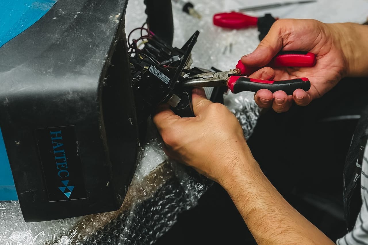 Appliance repair Charleston WV: Man repairs drone using pliers in workshop
