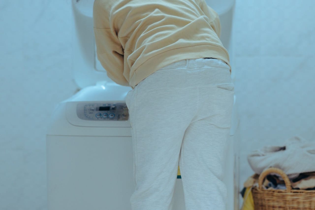 Appliance repair El Paso TX: Child loading washing machine in laundry room