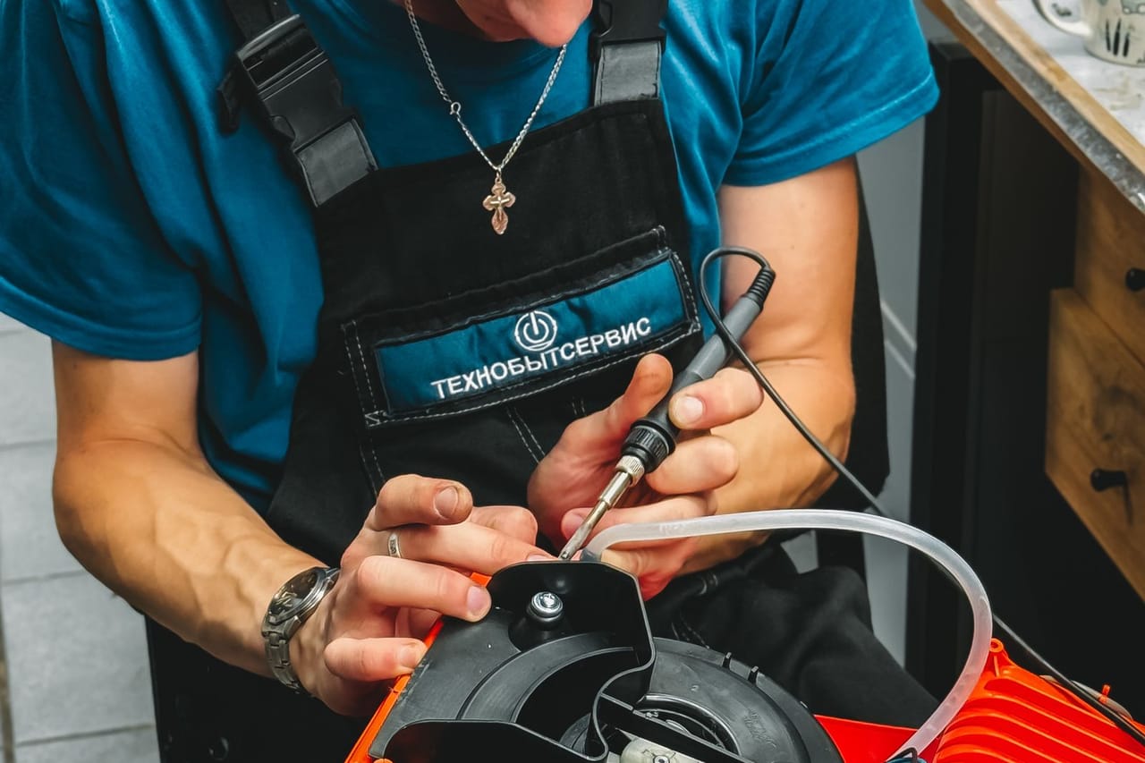 Appliance repair Escondido CA: Technician repairing machine in workshop