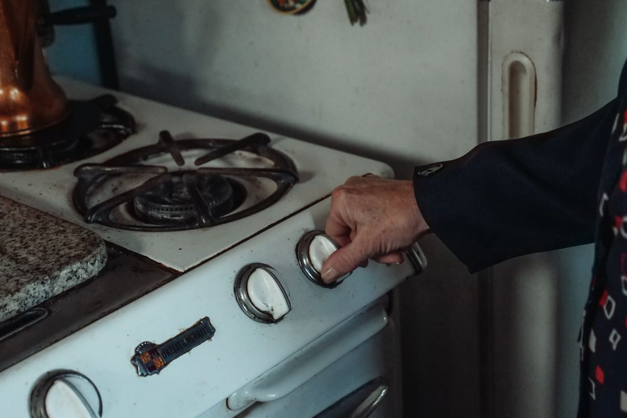 Appliance repair Fairbanks AK: A person holding a knob on a gas stove