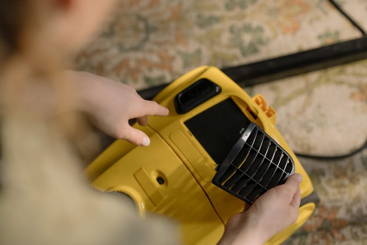 Appliance repair Garland TX: Person holding a yellow vacuum