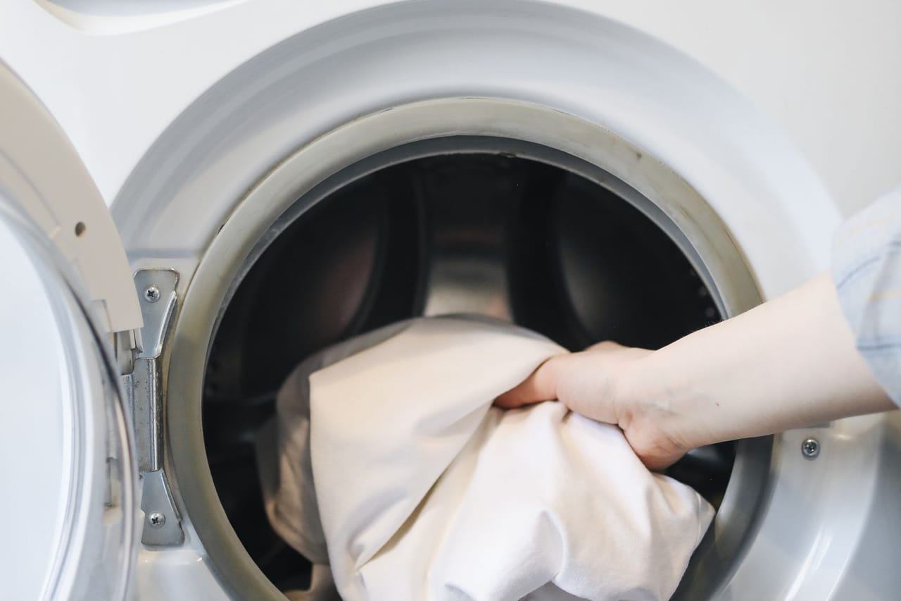 Appliance repair Naples FL: A person putting clothes in a washing machine