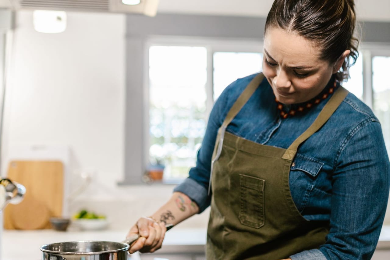 Appliance repair Ocala FL: Woman using cooker in domestic kitchen