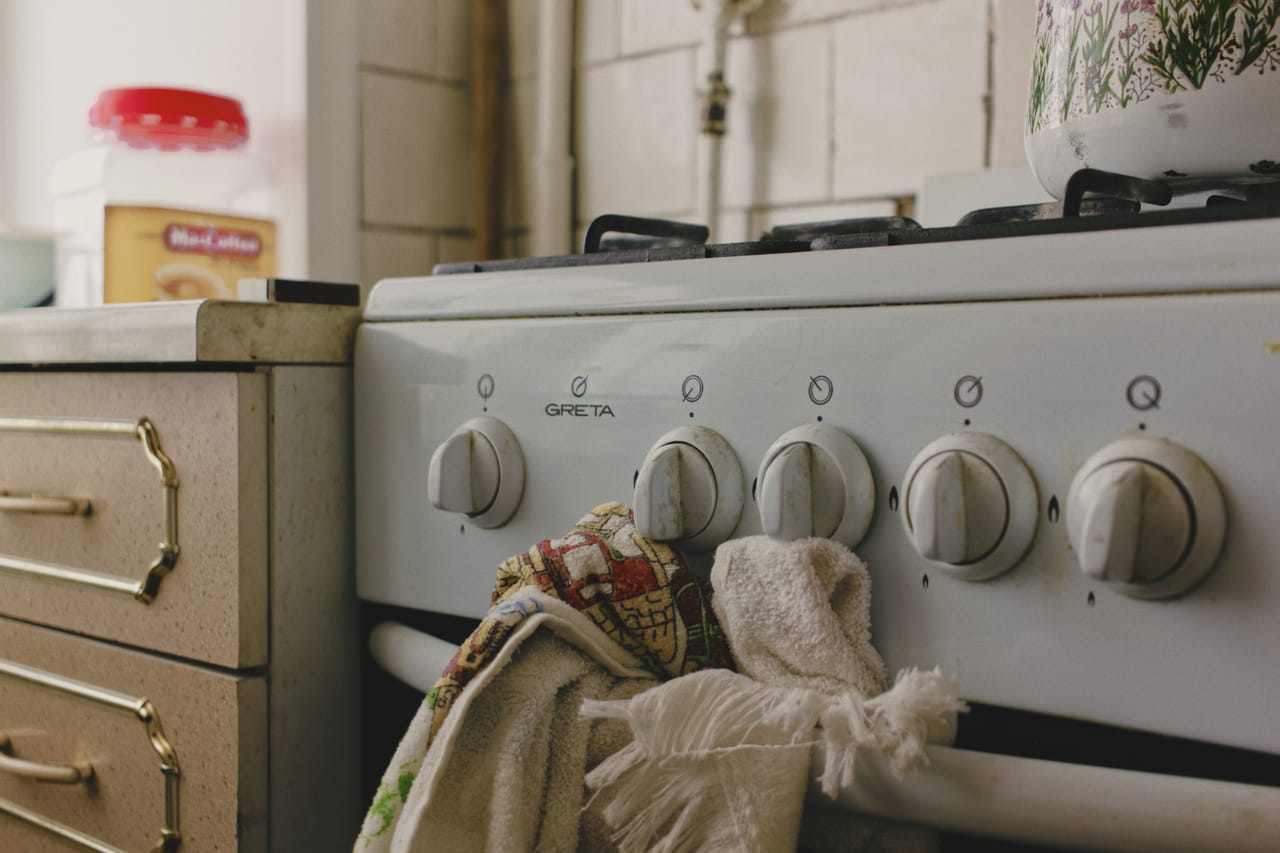 Appliance repair Pasadena TX: Vintage gas stove with kitchen towels in cozy setting