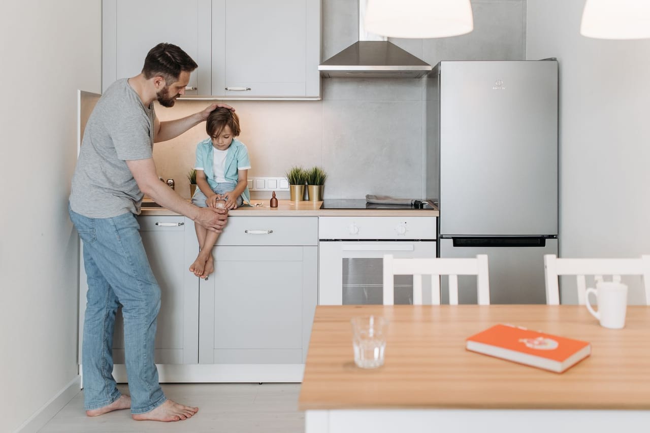 Appliance repair Petaluma CA: A father talking to his son sitting on the kitchen countertop