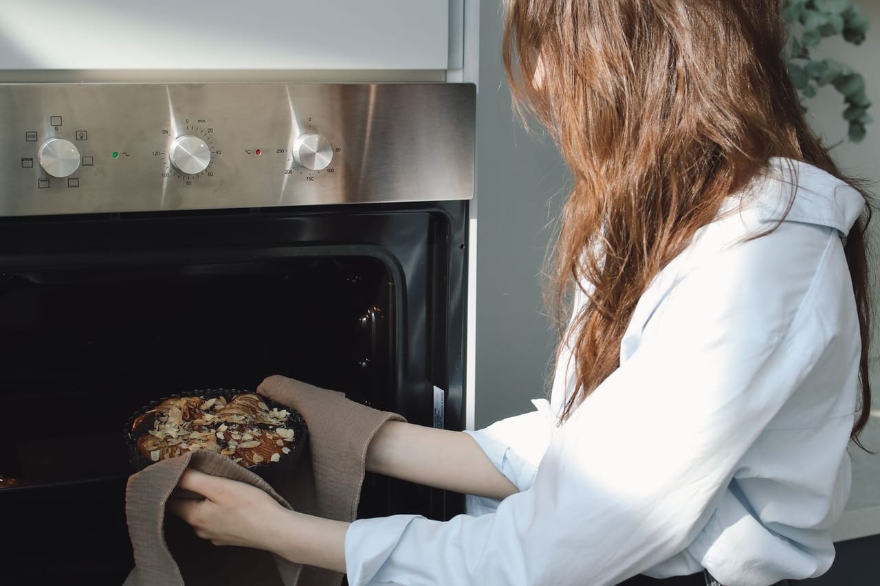 Appliance repair Racine WI: A woman cooking using oven