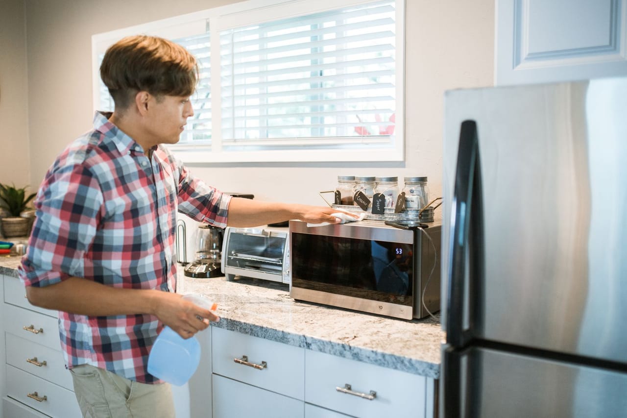 Appliance repair Ruston LA: A man wiping a microwave oven