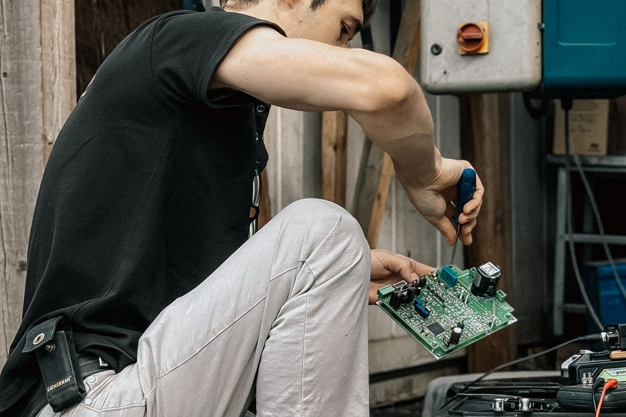 Appliance repair St Joseph MO: Technician repairing equipment outdoors