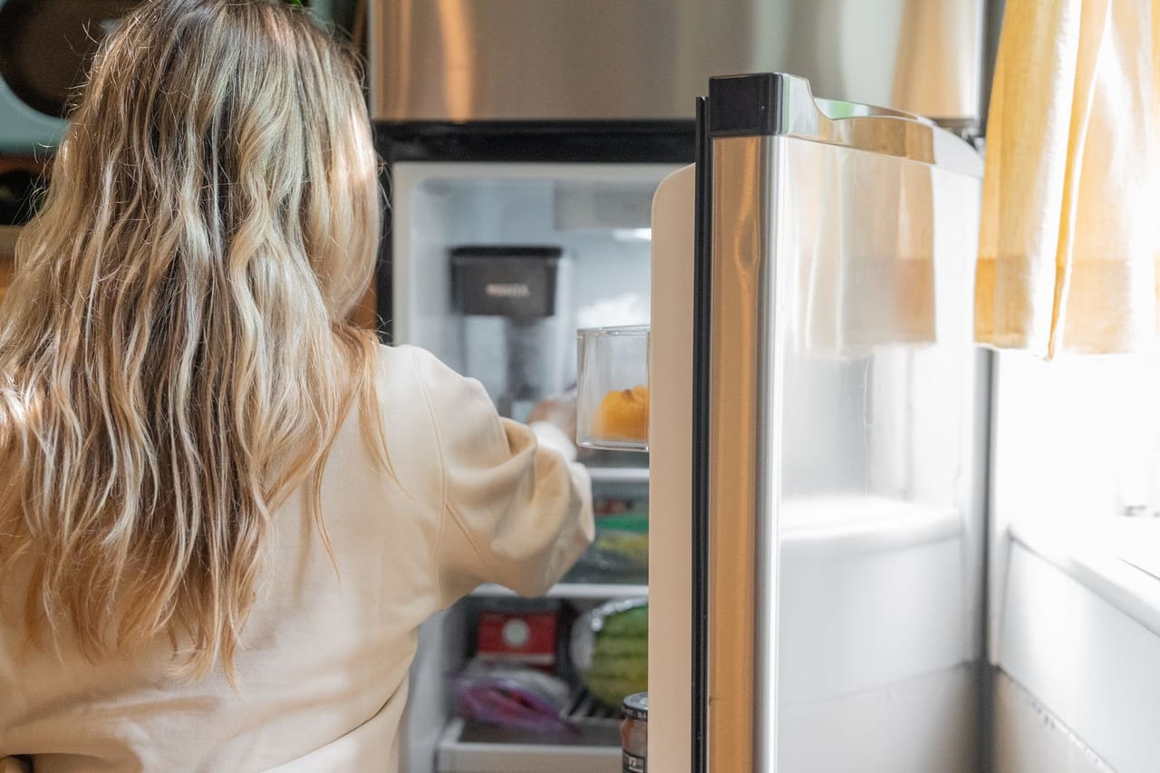 Appliance repair St Louis MO: Woman getting some foods in the refrigerator