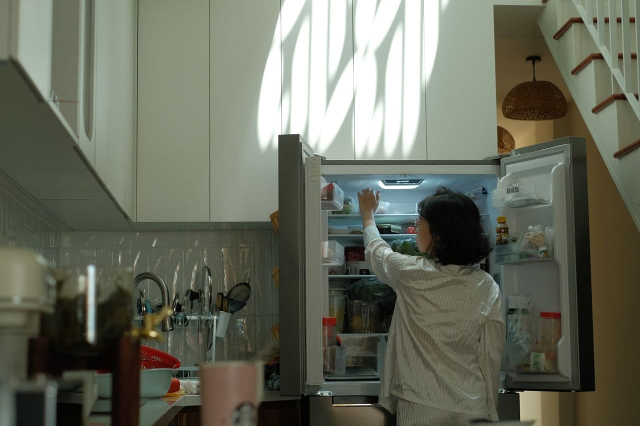 Appliance repair State College PA: Woman exploring fridge in cozy kitchen