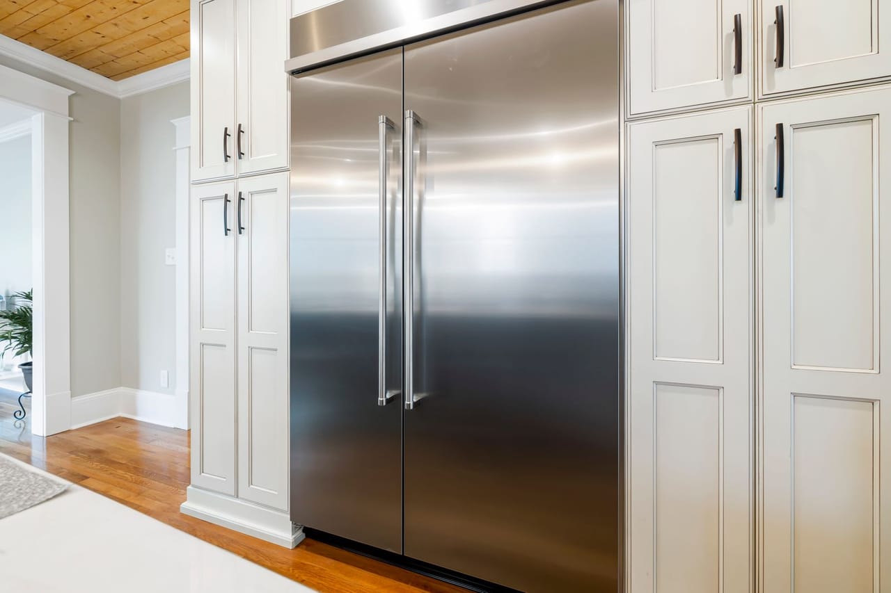 Appliance repair Staten Island NY: A stainless steel refrigerator surrounded with wooden cabinets