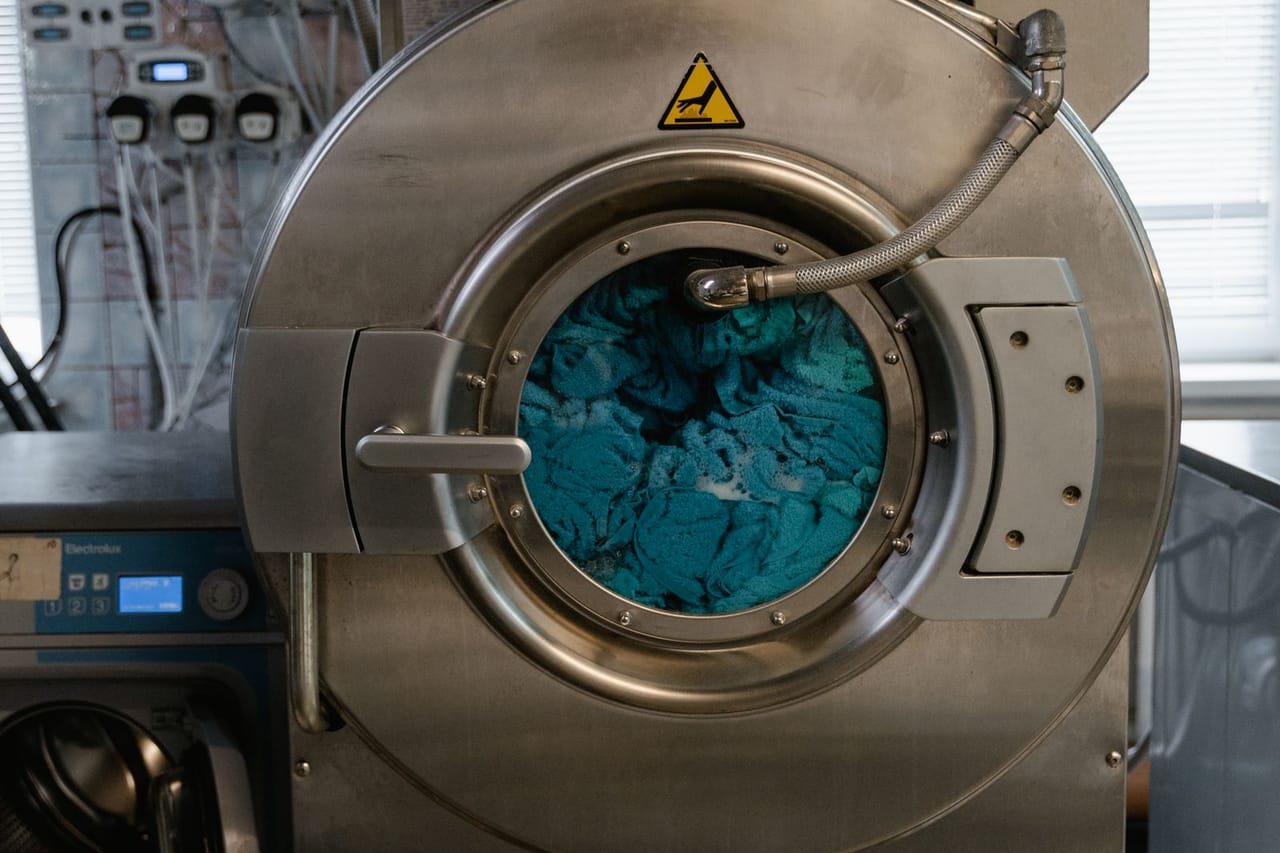 Appliance repair Trenton NJ: Washing machine with blue clothes inside