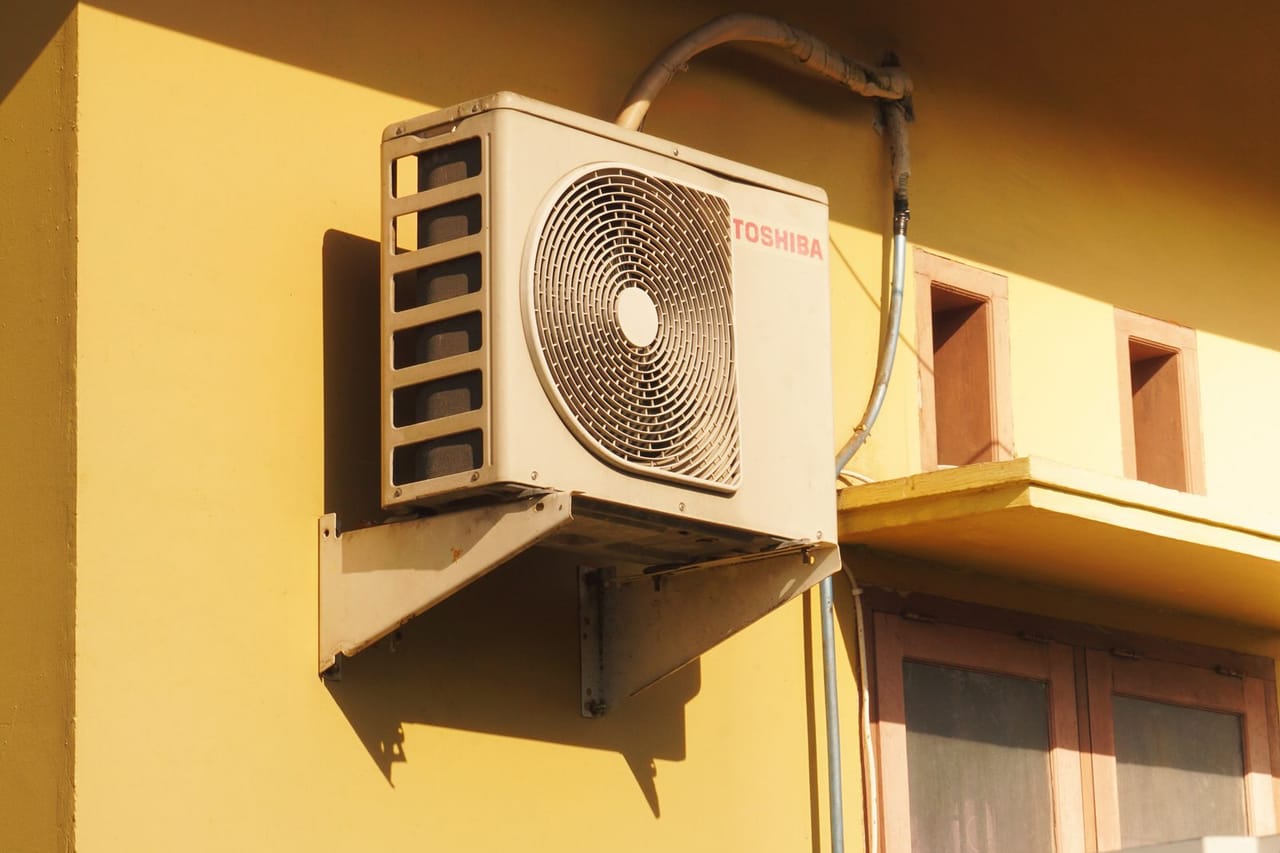 Appliance repair Vail CO: Toshiba outdoor air conditioner unit on yellow wall