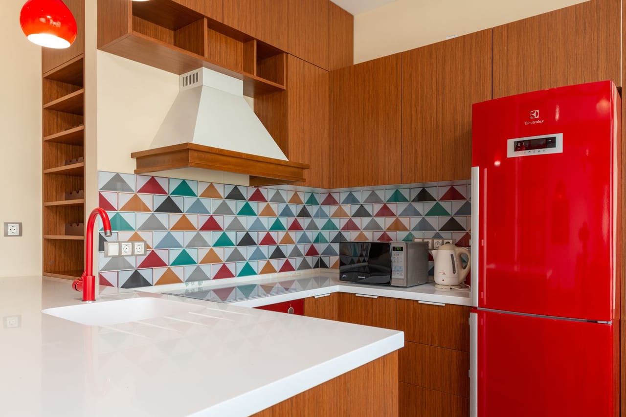 Appliance repair Zanesville OH: Kitchen interior with colorful tiles and red refrigerator