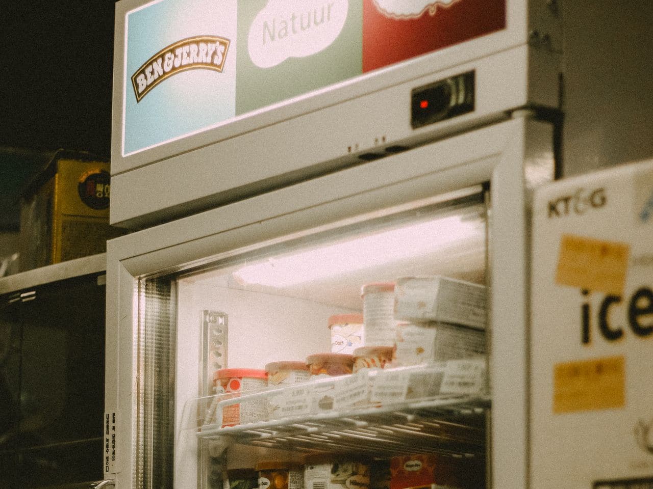 Average life of a refrigerator: old refrigerator with stickers in a dim room