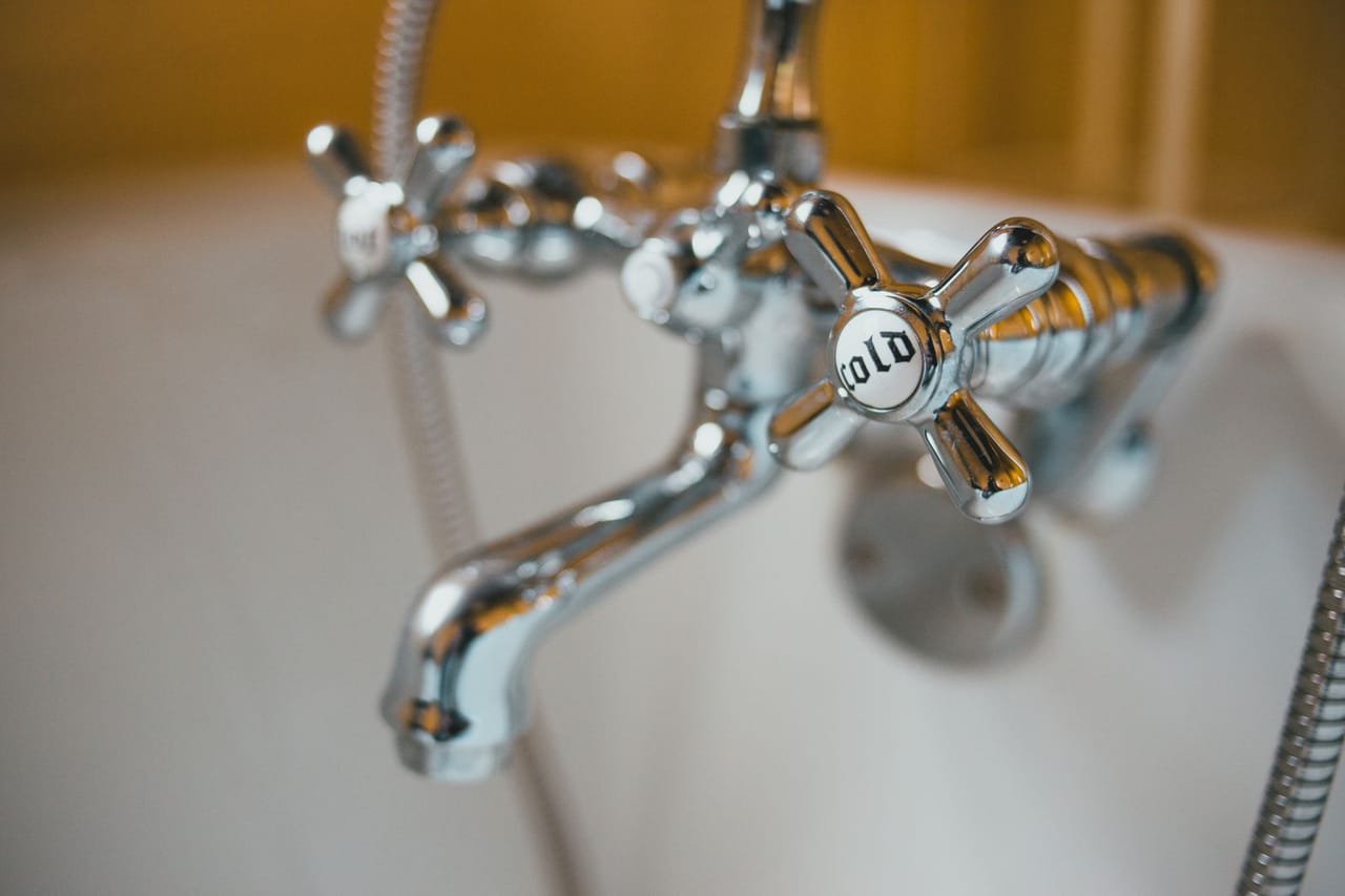 Bathtub faucet leaking: Close up of silver bathtub faucet knobs