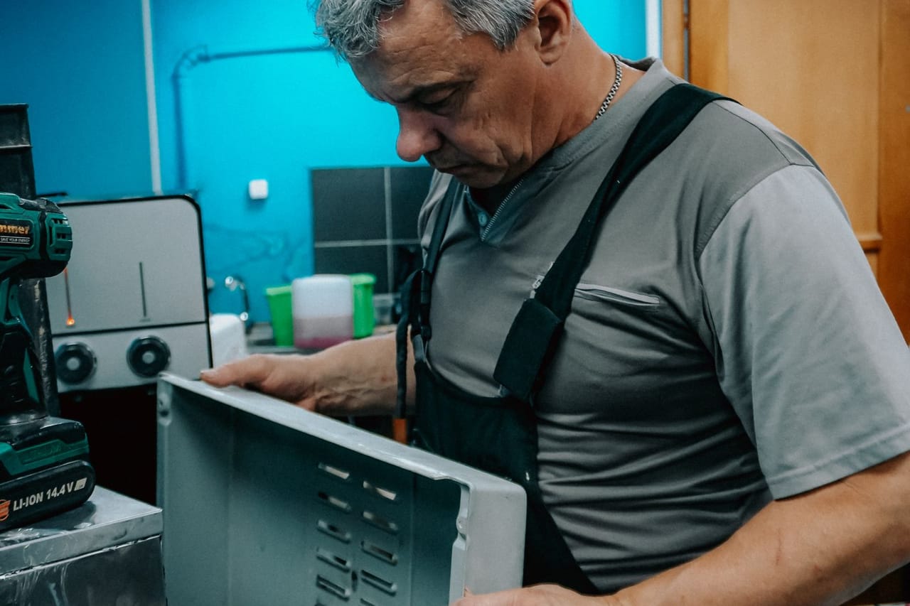 Cost of dryer repair: Repair technician working on appliance