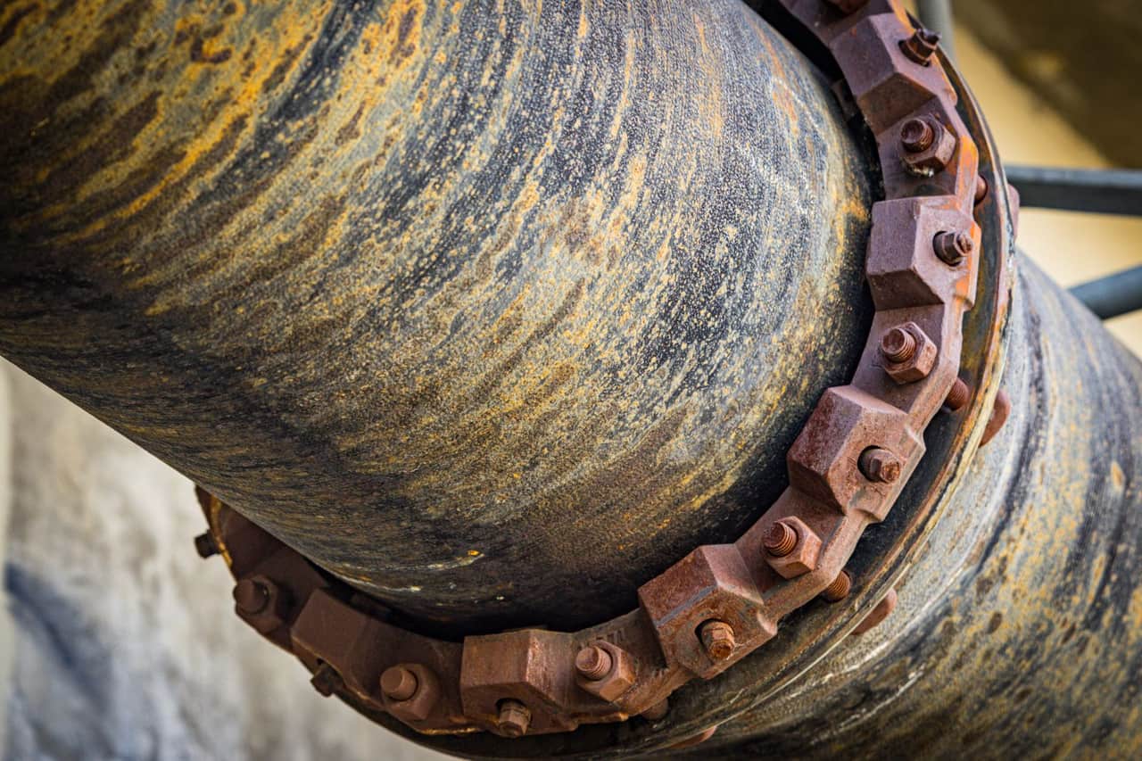 Cost of fixing a burst pipe: Rusty screws on pipe