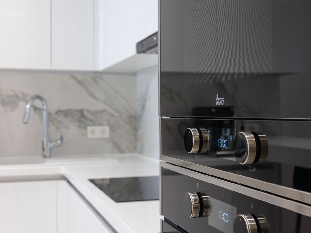 Dishwasher installation cost: white kitchen with a stainless steel oven and a sink