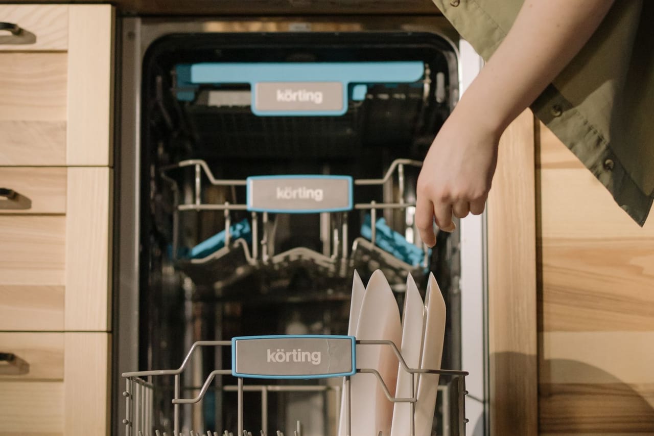 Dishwasher not cleaning dishes: Person using dishwasher for cleaning plates