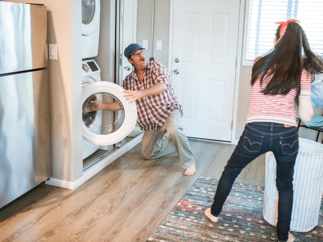 Dryer not spinning: man and woman near a laundry washer and dryer at home