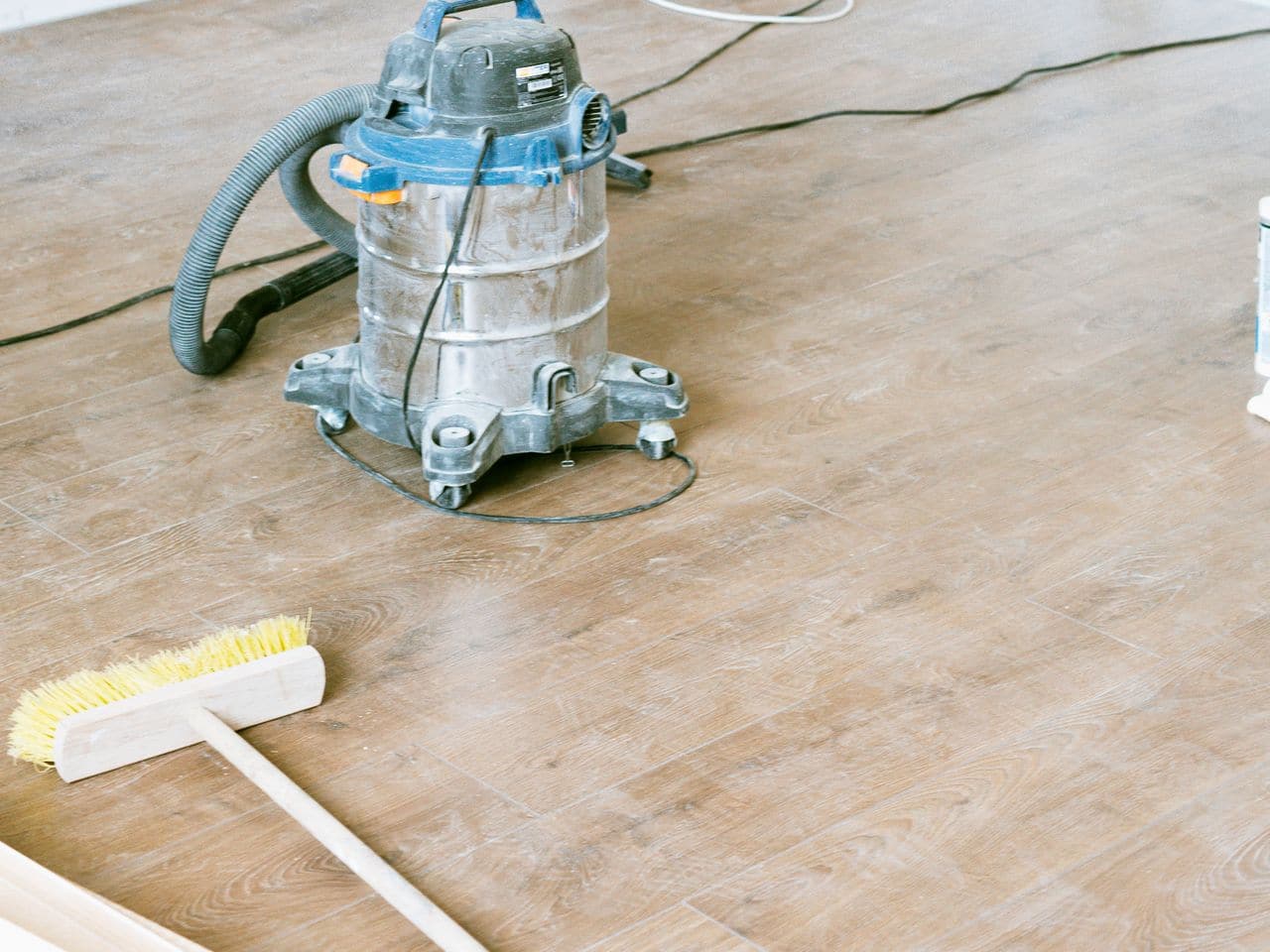 Dryer vent cleaning cost: canister vacuum cleaner on a wood floor