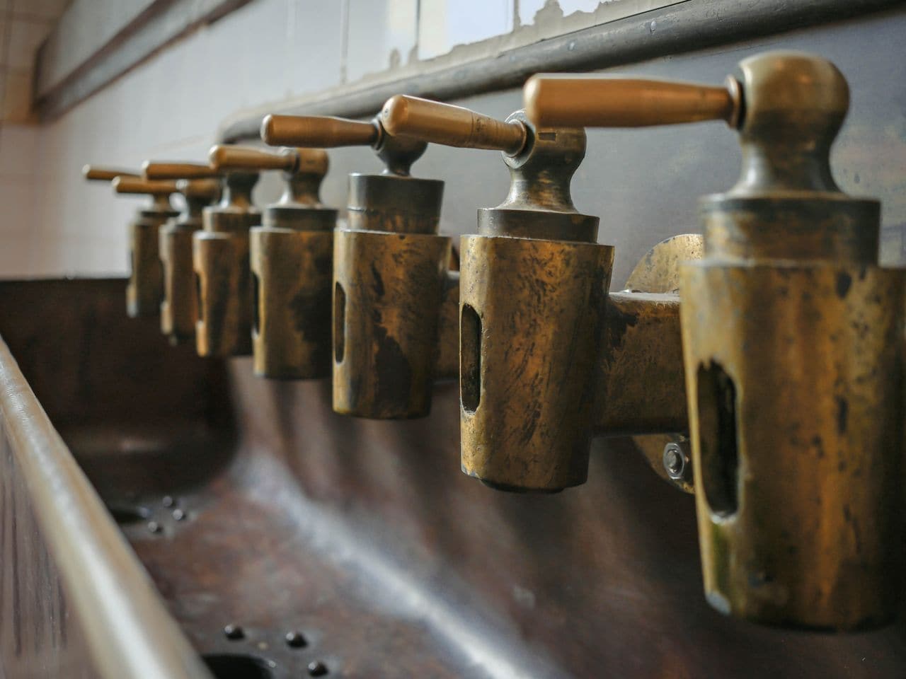 Gas vs electric water heater: row of brass valves on a pipe manifold