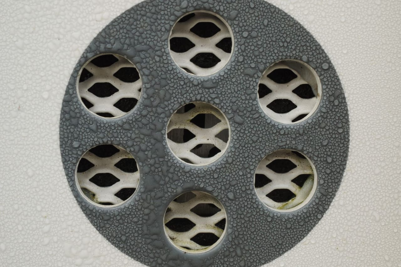 How does a french drain work: Close up of water droplets on metal drain