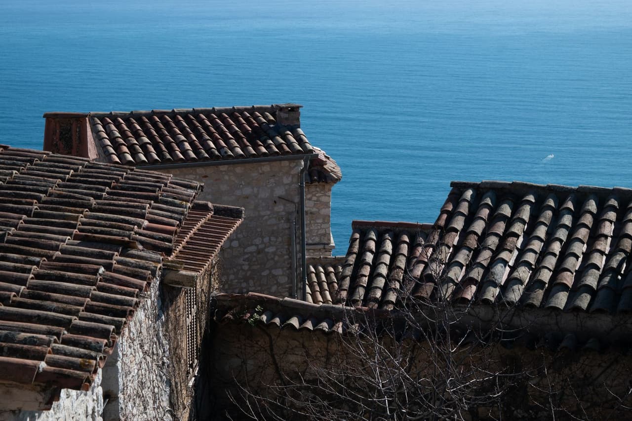 How long do roof shingles last: Rustic rooftops overlooking coastline