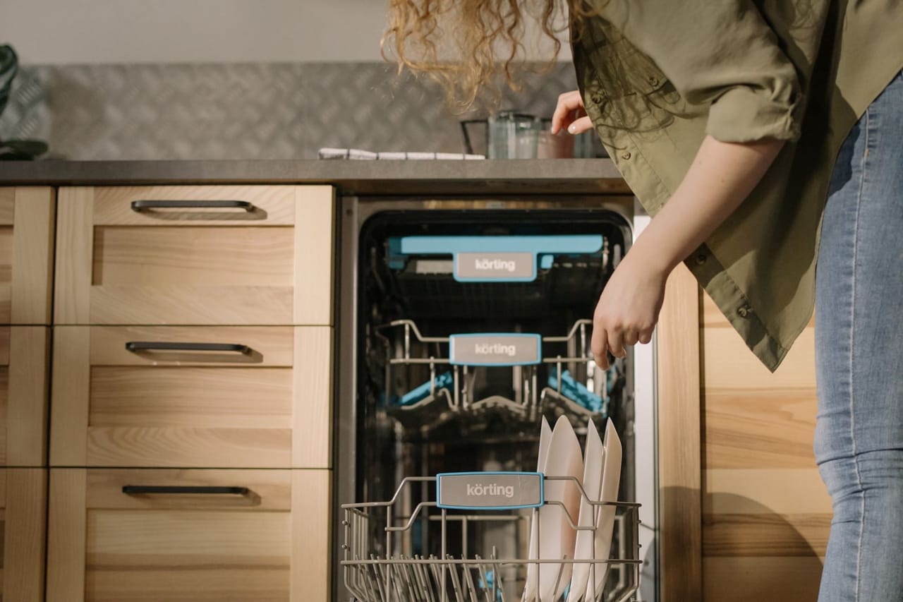 How long does a dishwasher take to run: Woman using dishwasher
