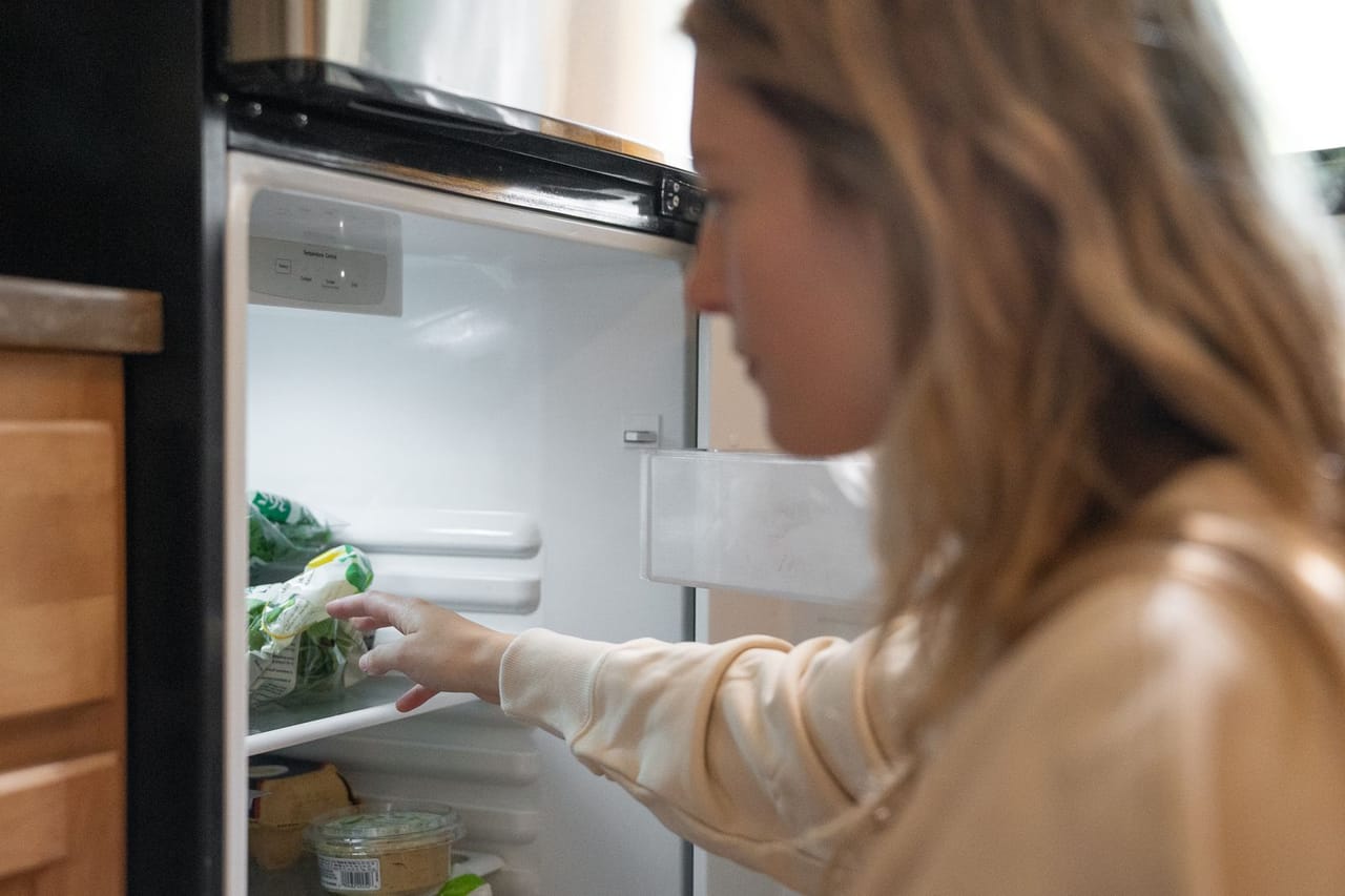 How long does food last in a refrigerator without power: Woman in brown long sleeve shirt looking in the refrigerator
