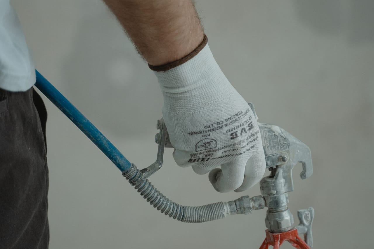 How much does a plumber cost: Plumber holding silver faucet