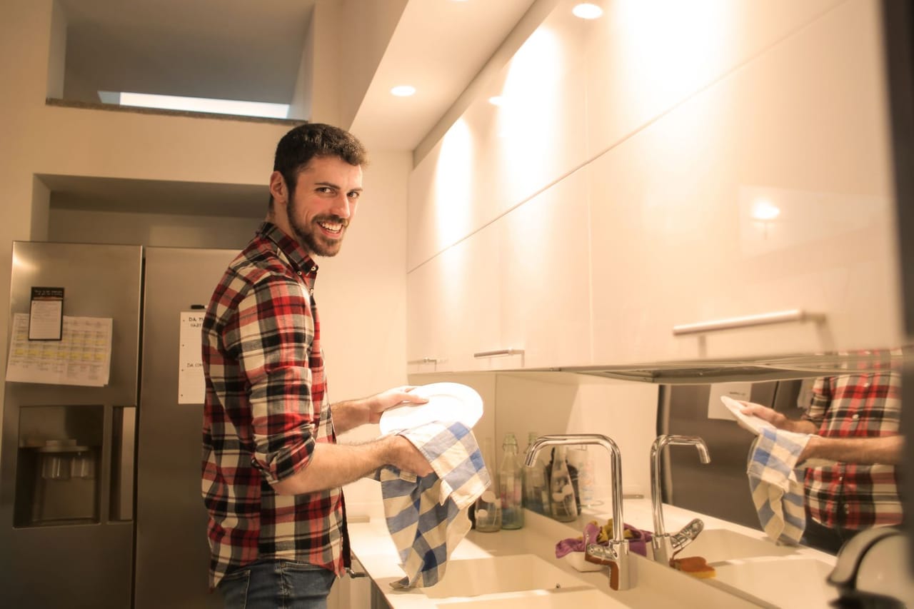 How to clean a dryer vent: Man wiping the dish plates clean
