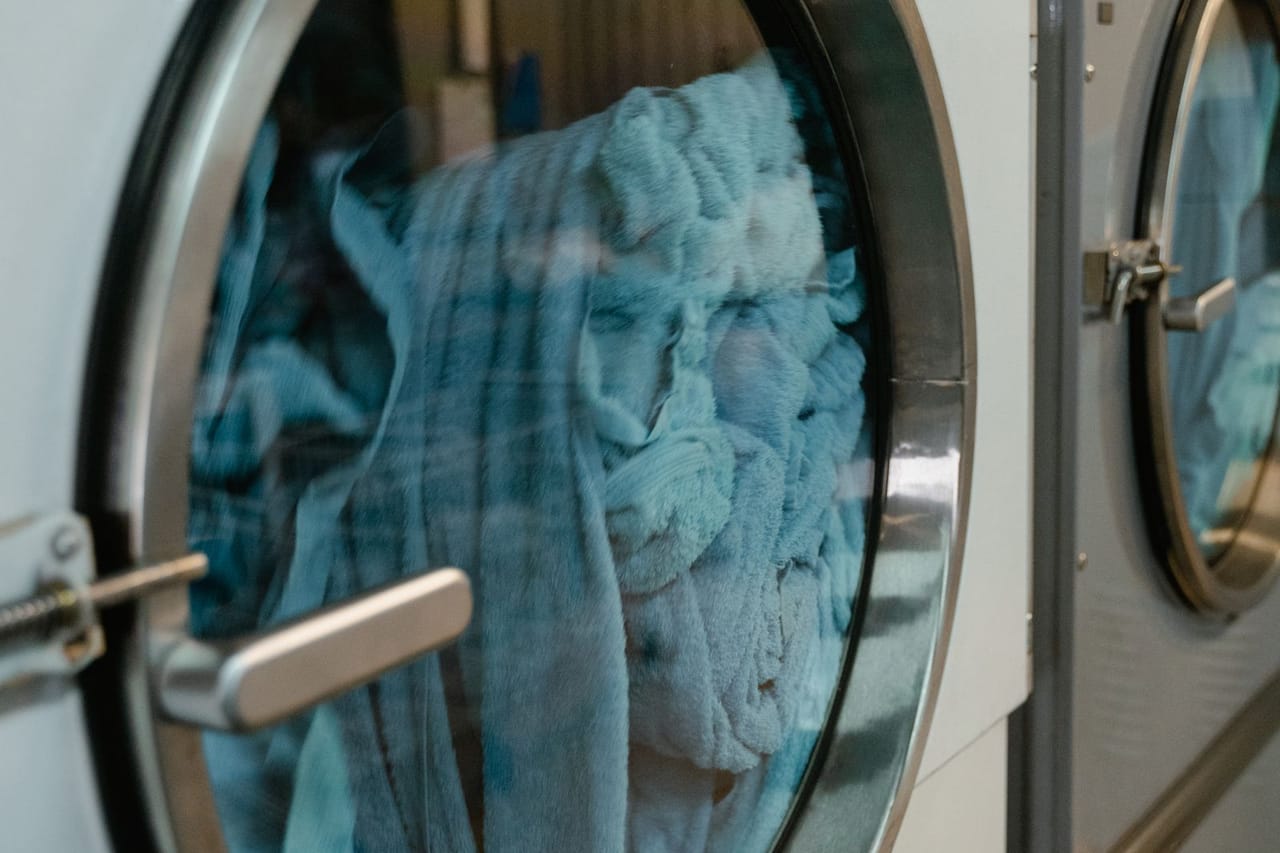 How to clean a washing machine: Blue towels in a front load washing machine