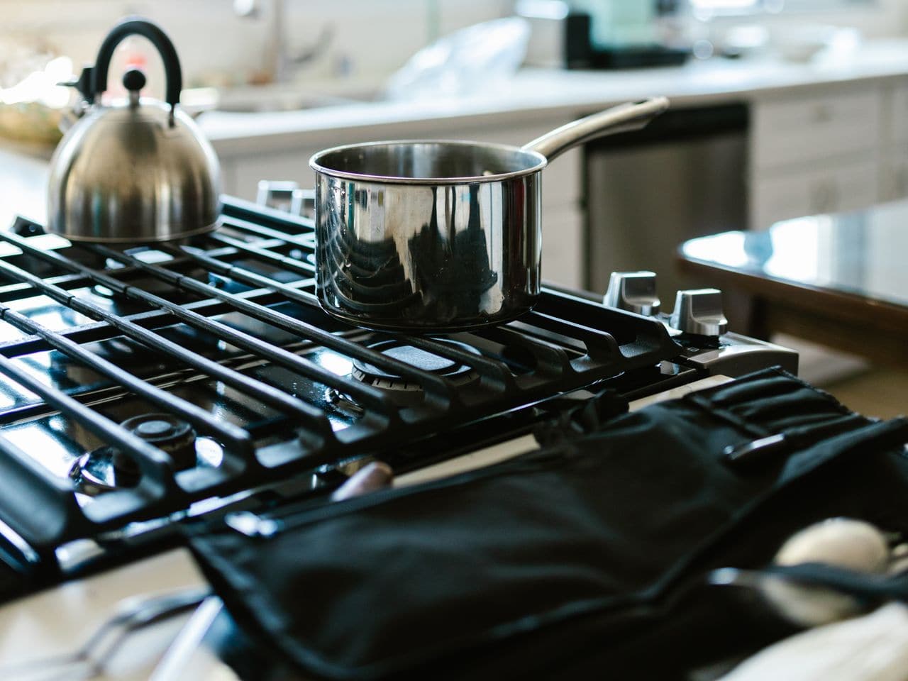 How to clean gas stove burners: kettle and pots sitting on a kitchen stove