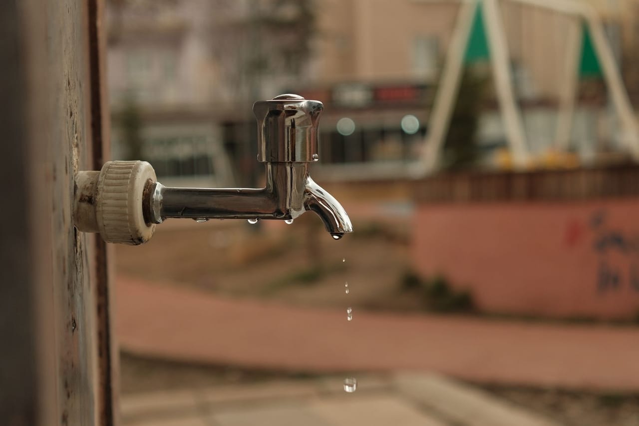 How to fix a leaky faucet: Outdoor water faucet dripping in urban setting