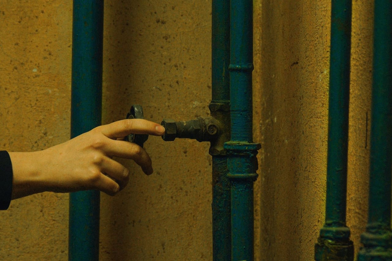 How to get rid of garbage disposal smell: Person holding a metal pipe