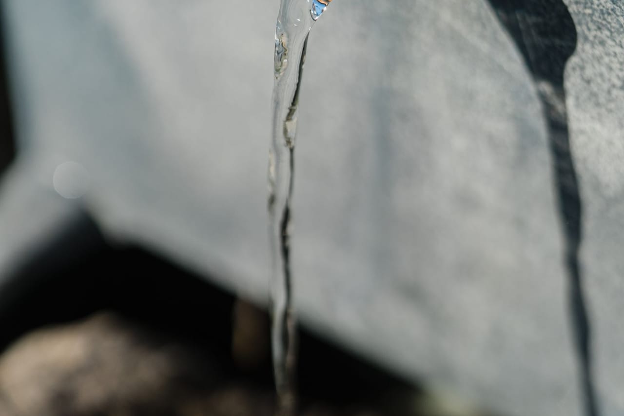 How to prevent burst pipe: Close up of water flowing from an old pipe