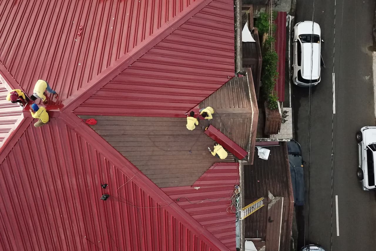 How to prevent ice dams on roof: People repairing house roof