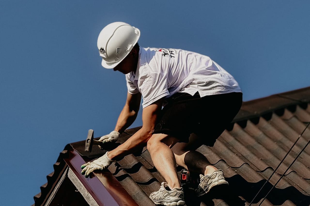 How to remove an ice dam: Professional roofer working safely on a building roof