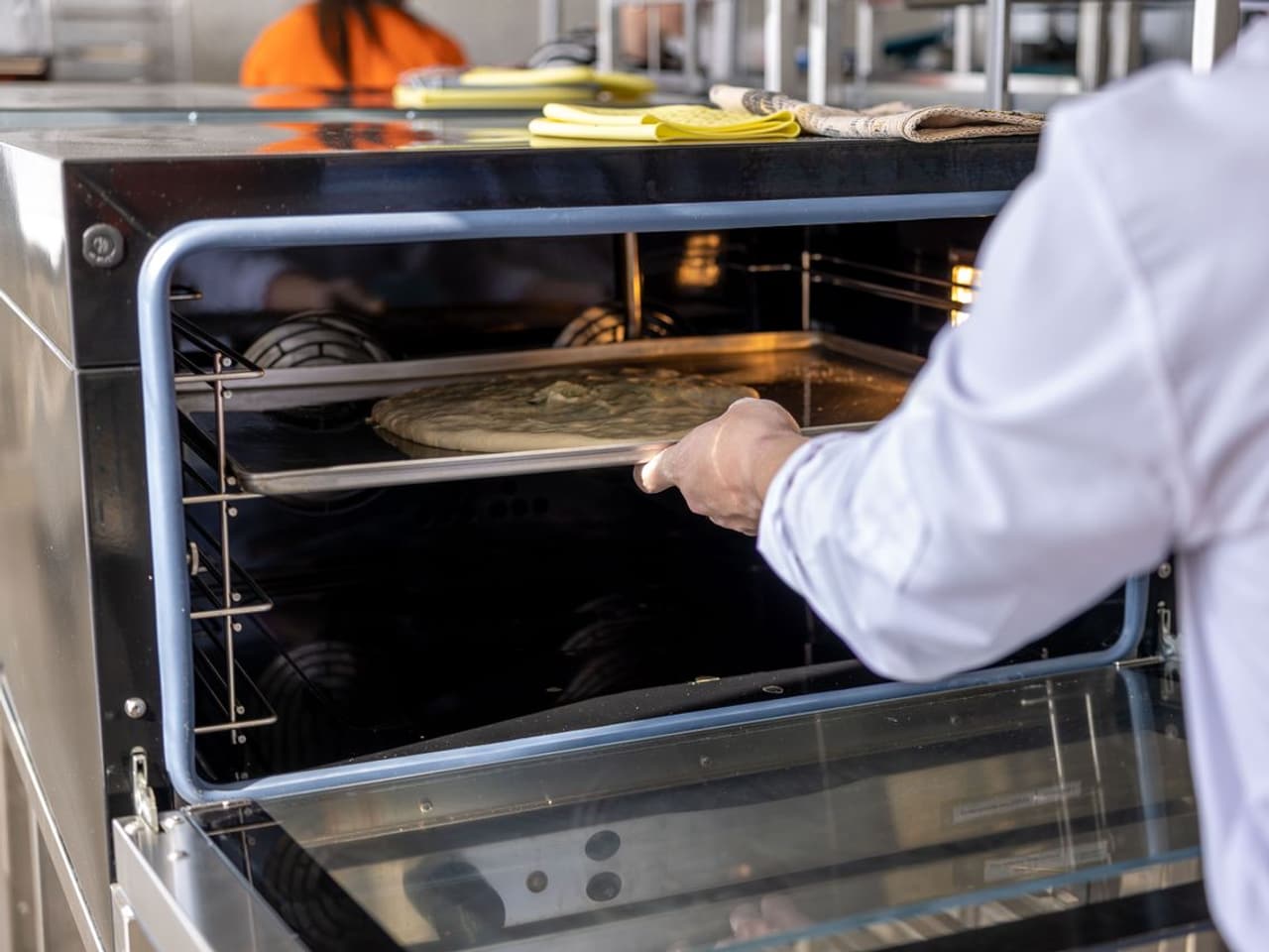 How to replace an oven heating element: person opening an oven with the light on inside