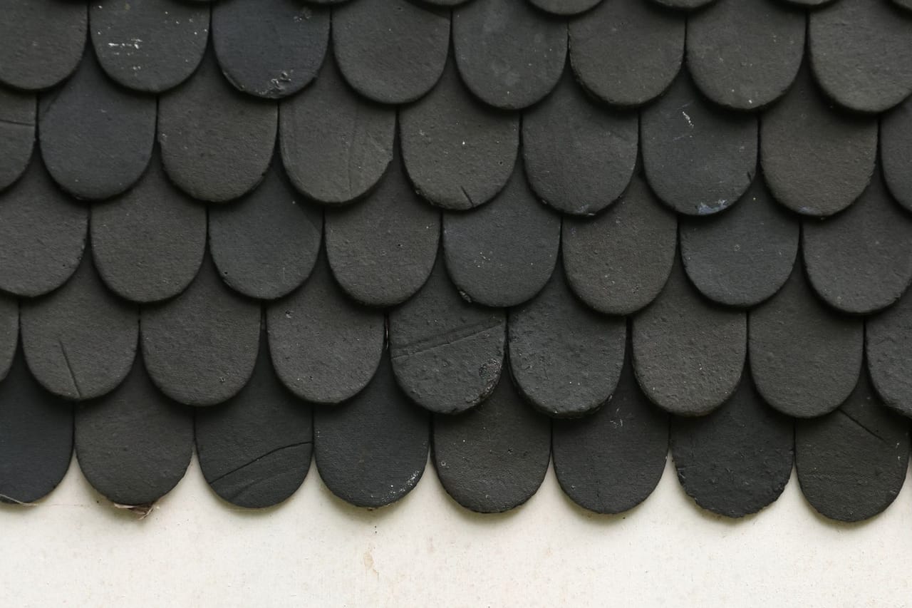 Metal roof vs shingles: Close up of black textured roof shingles