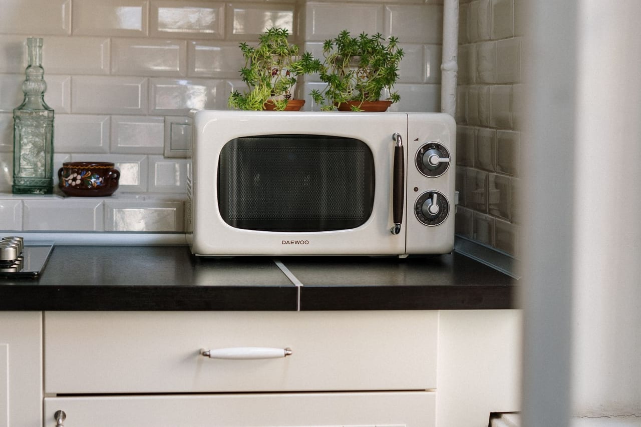 Microwave not heating: Silver microwave oven on white wooden cabinet