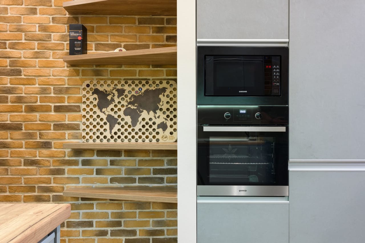 Microwave sparking: Shelves an oven and a microwave in a kitchen