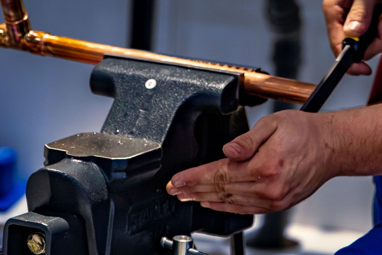 Pex vs copper pipe: Close up of plumber working with copper pipe