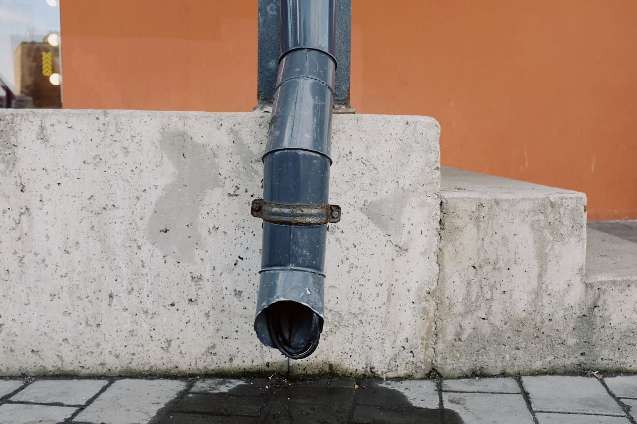 Plumber cost to snake drain: Water dripping from drain spout