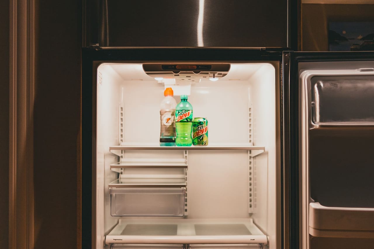 Refrigerator leaking water inside: Mountain dew and gatorade inside an empty refrigerator