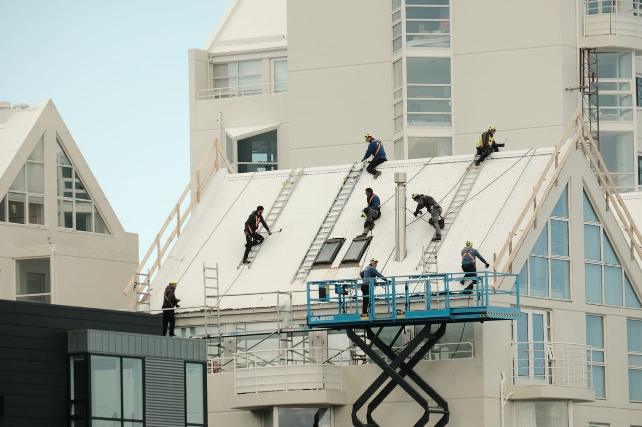 Roof damage insurance claim: Workers repairing roof